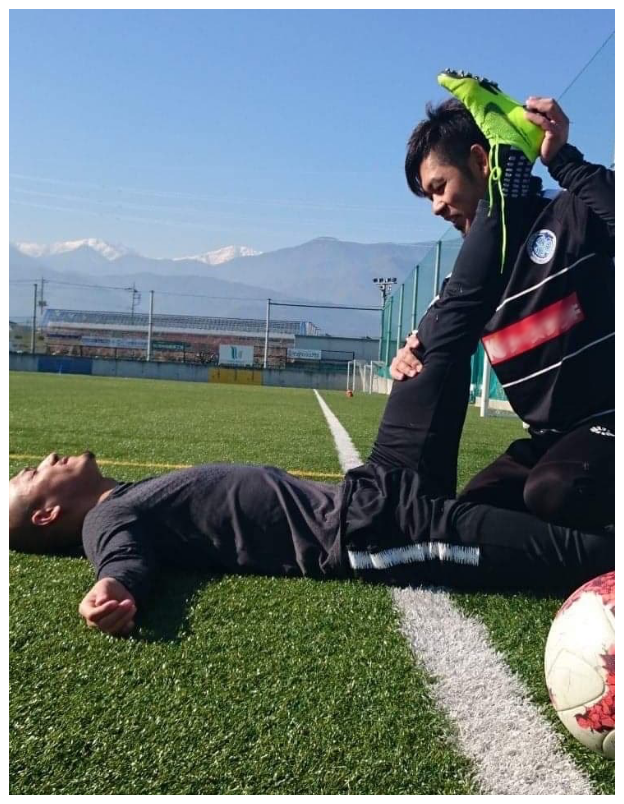 プロサッカー選手のケアをするトレーナー